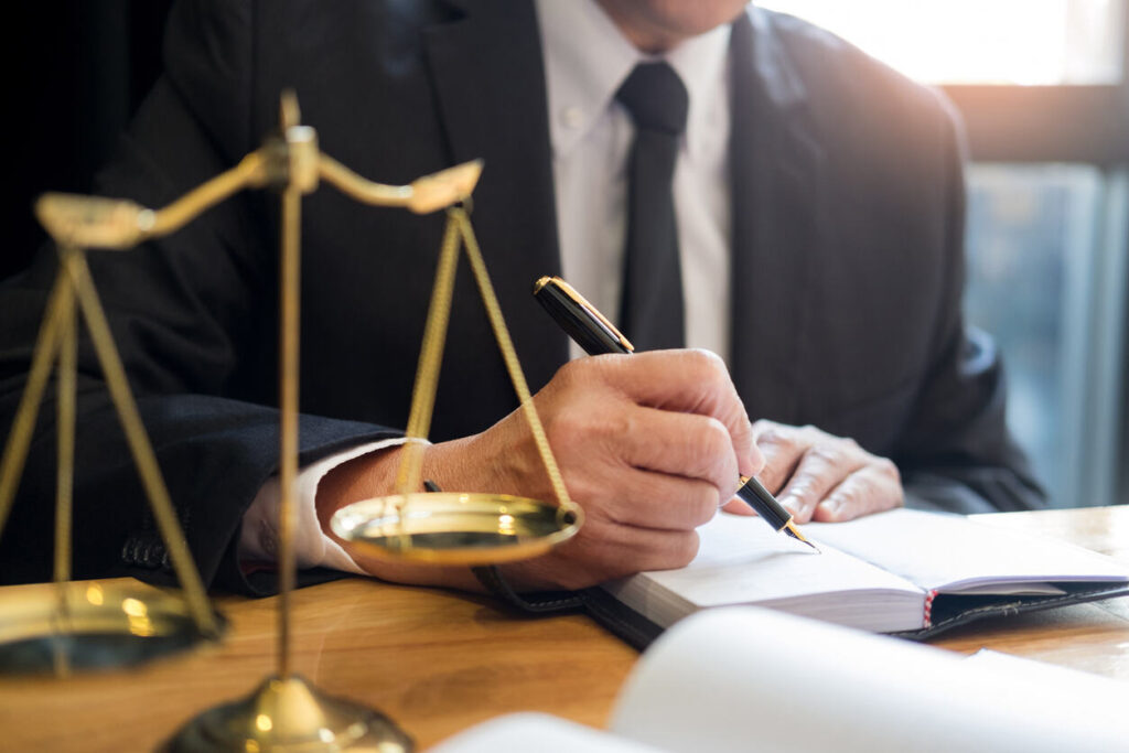 Lawyer sitting on the table and writting something about the case