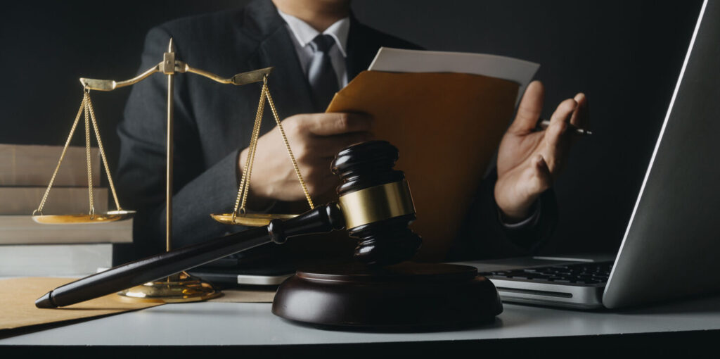 Gavel is on the table and lawyer is reading about the case