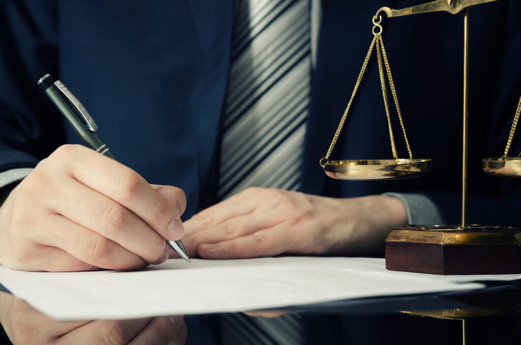 Lawyer is sitting on table and writting something about the case