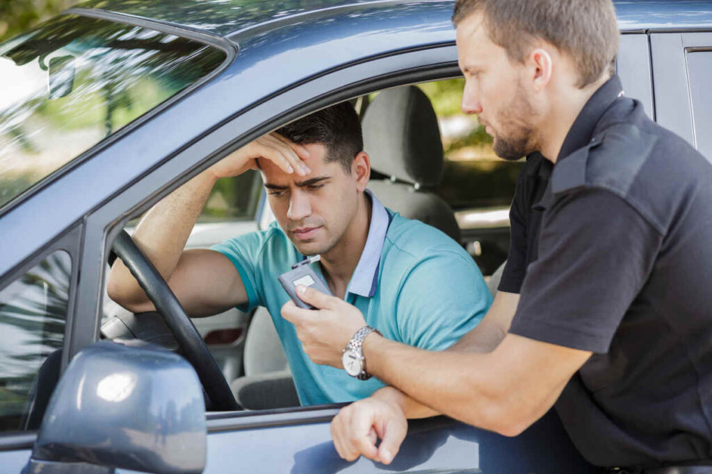 Police officer administering breathalyzer test to concerned driver during DUI stop in Myrtle Beach