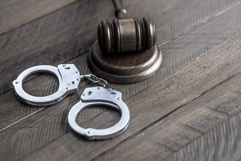 A judge's gavel and handcuffs on a wooden surface, symbolizing the serious legal consequences of a minor-related sex crime charge and the need for a defense lawyer in Columbia.